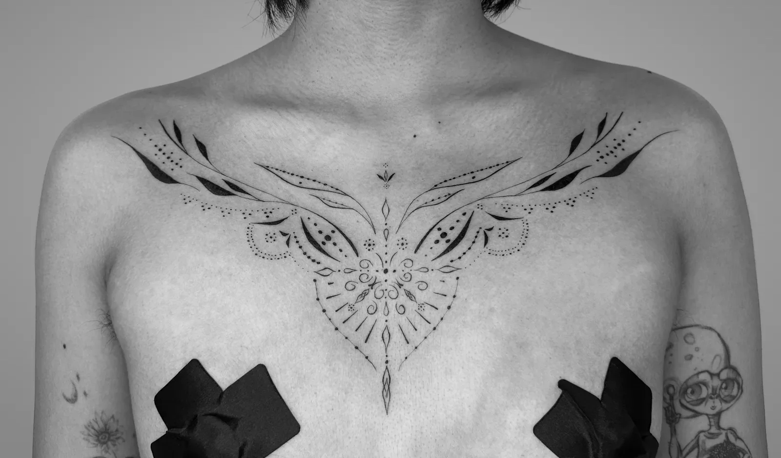 Fine ornamental linework arranged across the chest